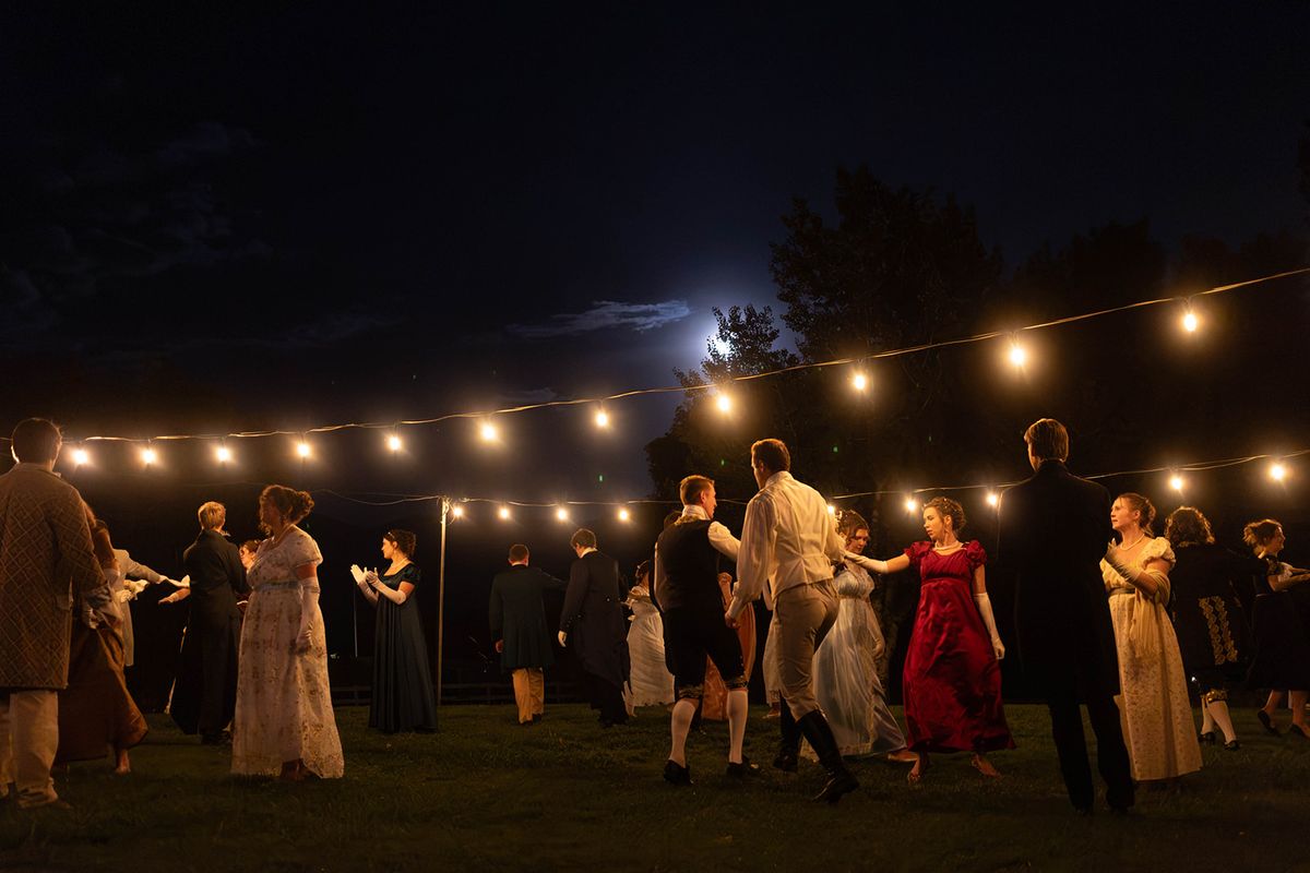 Guests dancing on the lawn at night beneath strings of glowing bistro lights